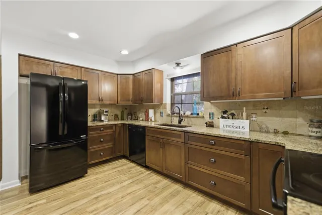a kitchen with granite countertop stainless steel appliances and wooden cabinets