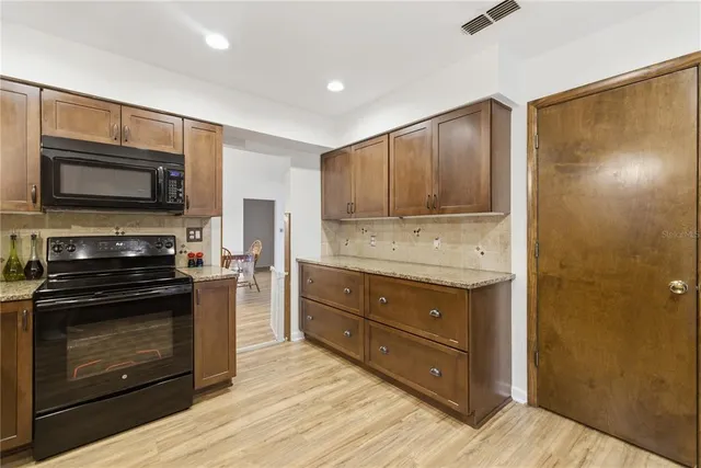 a kitchen with granite countertop wooden cabinets and stainless steel appliances