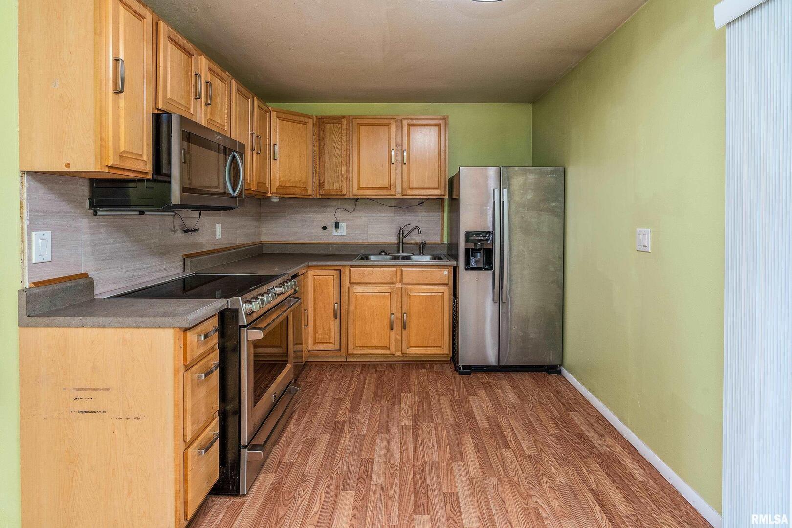 309 South Plover Drive Carbondale, IL 62901 - Photo 7 of 29 a kitchen with granite countertop wooden floors and stainless steel appliances
