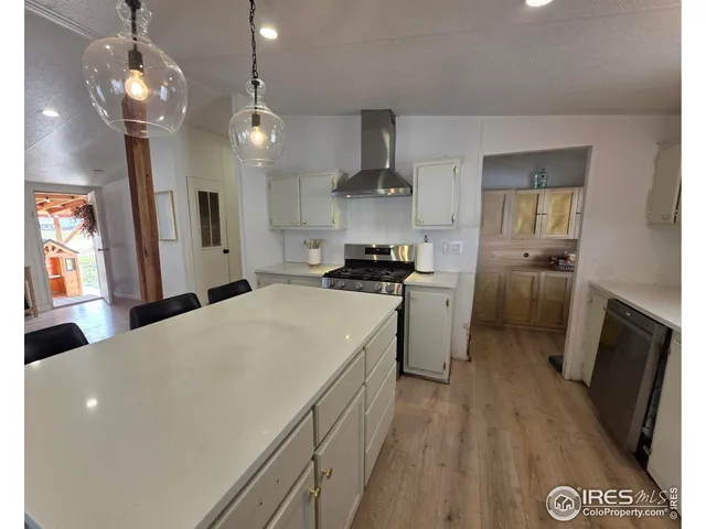 a kitchen with a stove a refrigerator a sink dishwasher with wooden floor and dining table