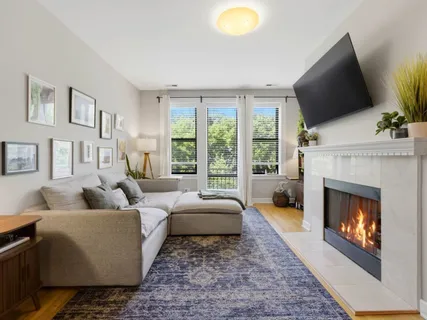 a living room with furniture a flat screen tv and a fireplace