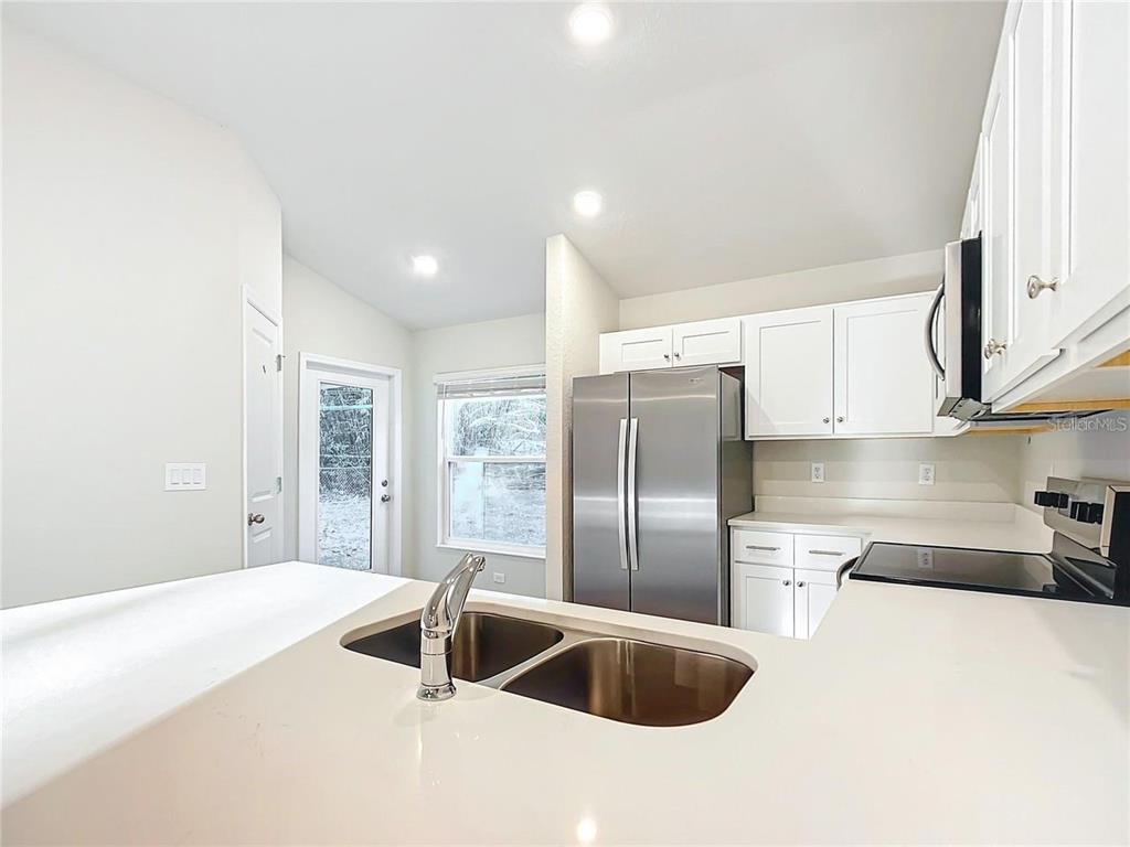 3070 East Odier Street Inverness, FL 34453 - Photo 13 of 14 a kitchen with stainless steel appliances granite countertop a sink and a refrigerator