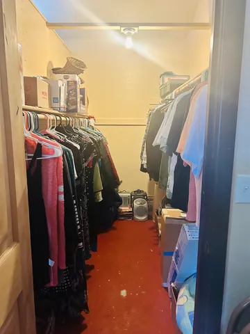 a view of walk in closet with clothes and shoes