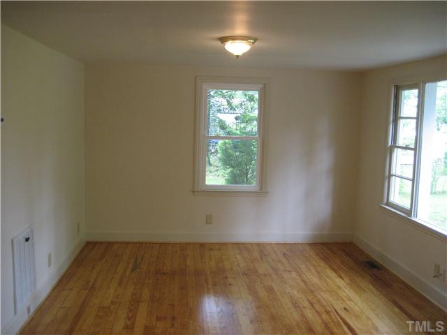 1218 Platinum Avenue Raleigh, NC 27610 - Photo 2 of 13 an empty room with wooden floor and windows