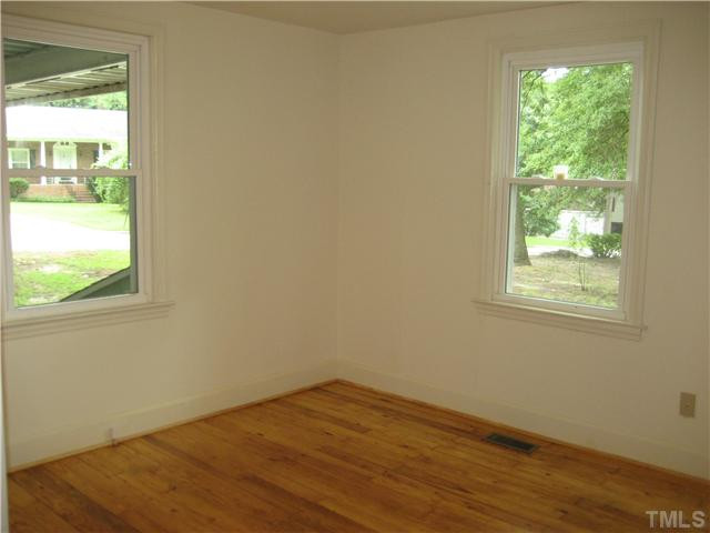 1218 Platinum Avenue Raleigh, NC 27610 - Photo 9 of 13 a view of an empty room with wooden floor and a window