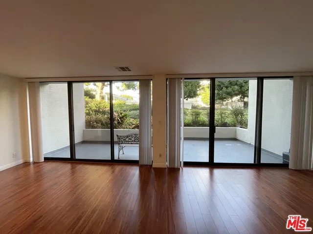a view of room with wooden floor and floor to ceiling window