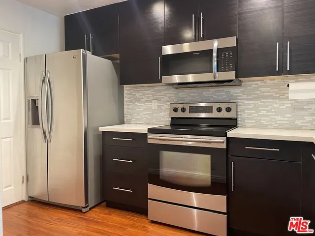 a kitchen with granite countertop stainless steel appliances and wooden cabinets