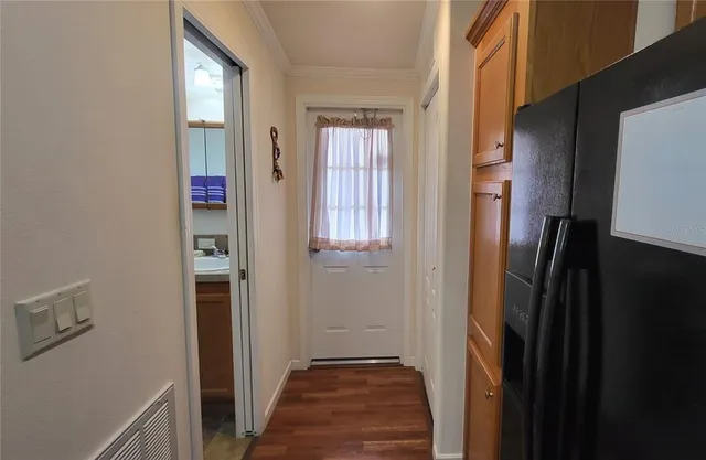 a view of a hallway with wooden floor and closet area