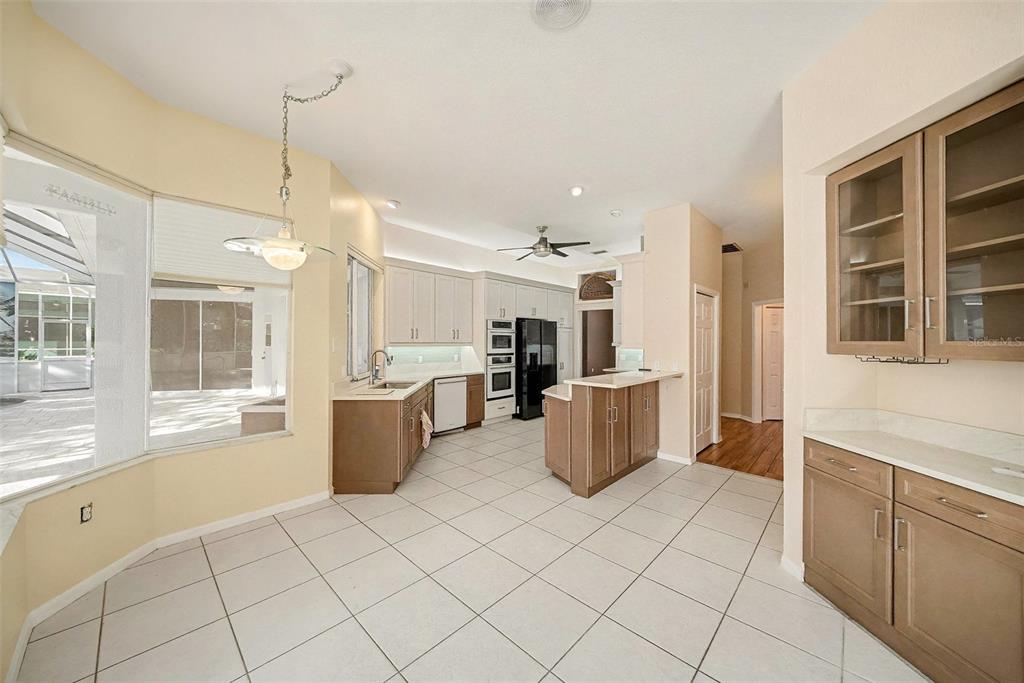 8402 Maybelle Drive Weeki Wachee, FL 34613 - Photo 13 of 41 a large white kitchen with a large window cabinets and stainless steel appliances
