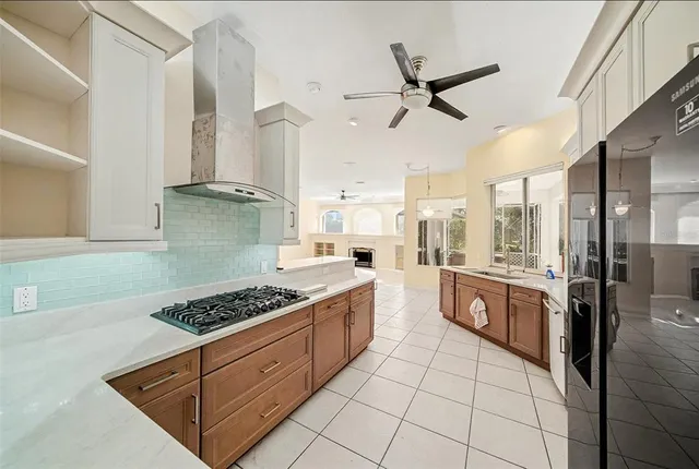 a kitchen with stainless steel appliances kitchen island granite countertop a sink and white cabinets
