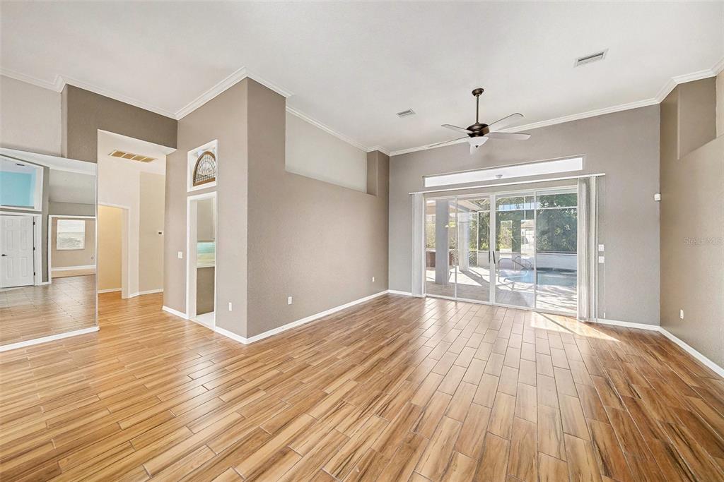 8402 Maybelle Drive Weeki Wachee, FL 34613 - Photo 5 of 41 a view of an empty room with wooden floor and a window