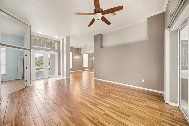 a view of an empty room with wooden floor and a window
