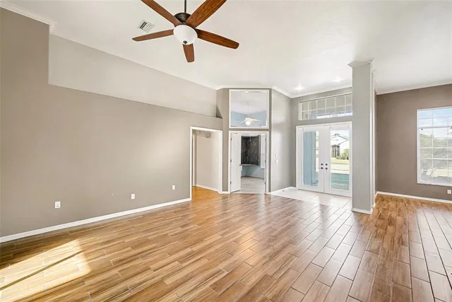 a view of a room with wooden floor and ceiling fan