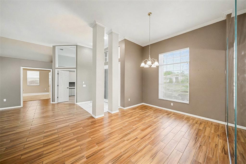 8402 Maybelle Drive Weeki Wachee, FL 34613 - Photo 9 of 41 a view of an empty room with window and wooden floor