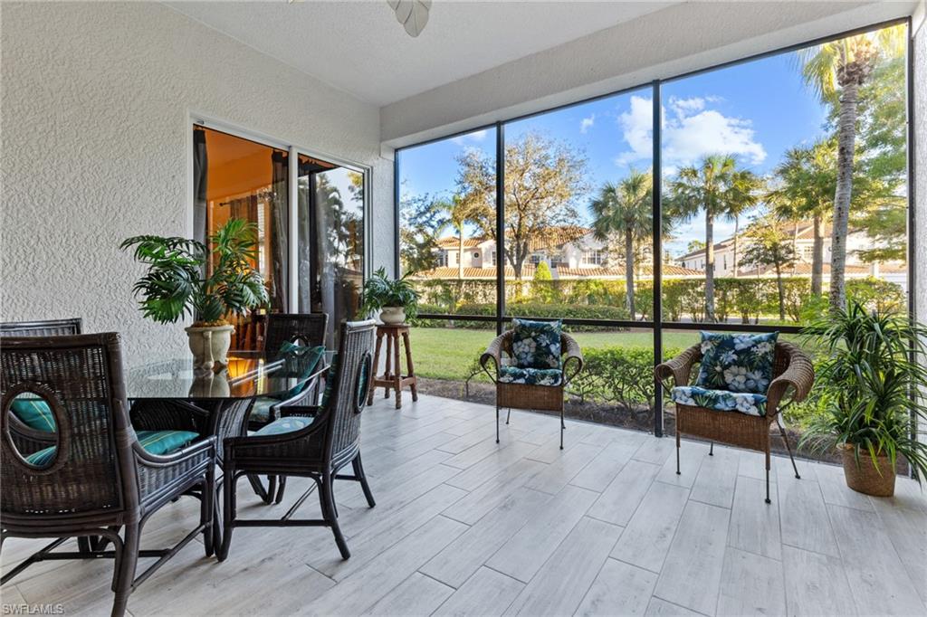 9079 Cascada Way, Unit 102 Naples, FL 34114 - Photo 20 of 49 a living room with furniture and a floor to ceiling window