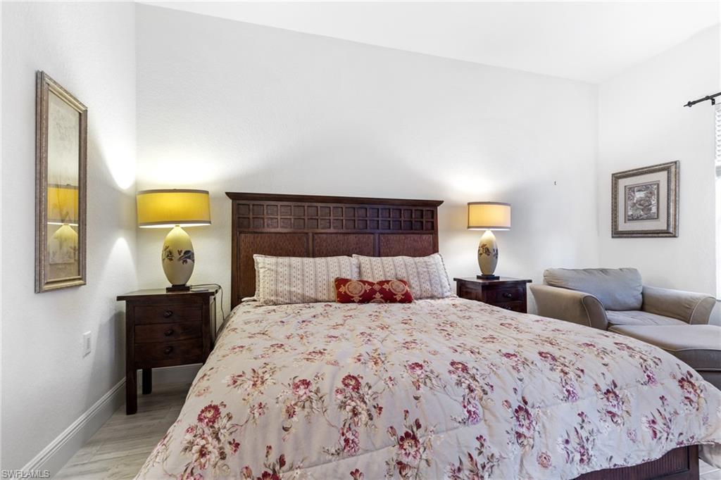 9079 Cascada Way, Unit 102 Naples, FL 34114 - Photo 23 of 49 a bedroom with a bed and lamp painting on the wall