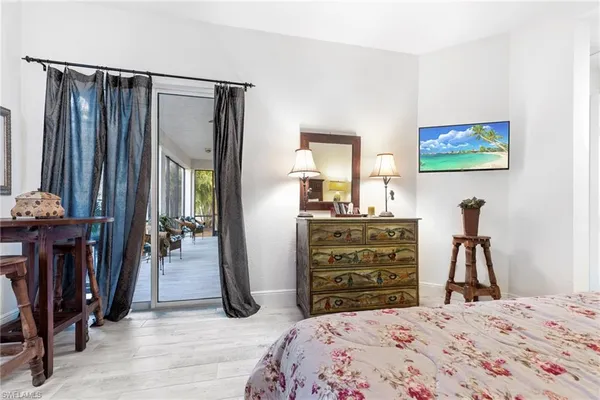 a bedroom with a bed and a flat tv screen on dresser