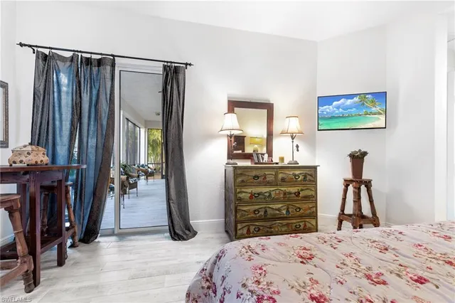 a bedroom with a bed and a flat tv screen on dresser