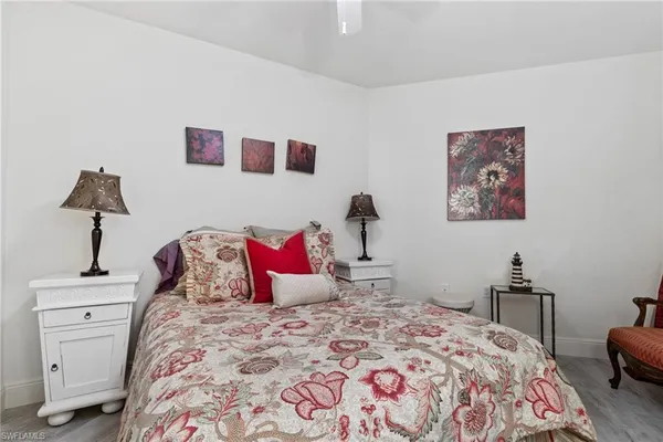 a bedroom with a bed and a lamp on dresser