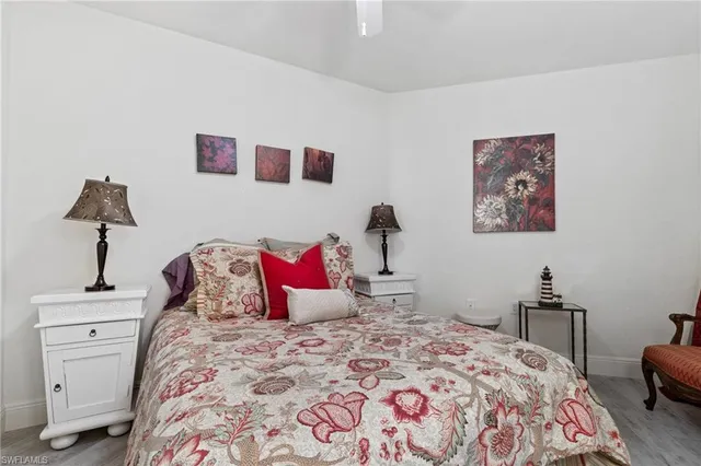 a bedroom with a bed and a lamp on dresser