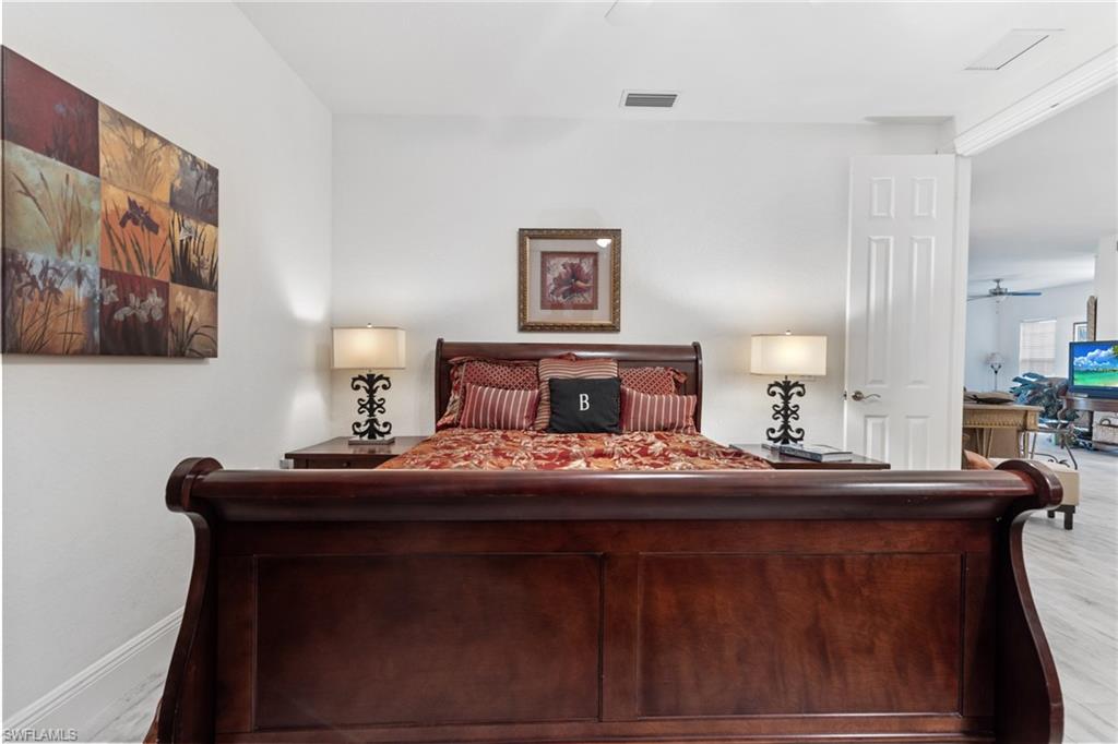 9079 Cascada Way, Unit 102 Naples, FL 34114 - Photo 34 of 49 a bedroom with a bed and a lamp on dresser