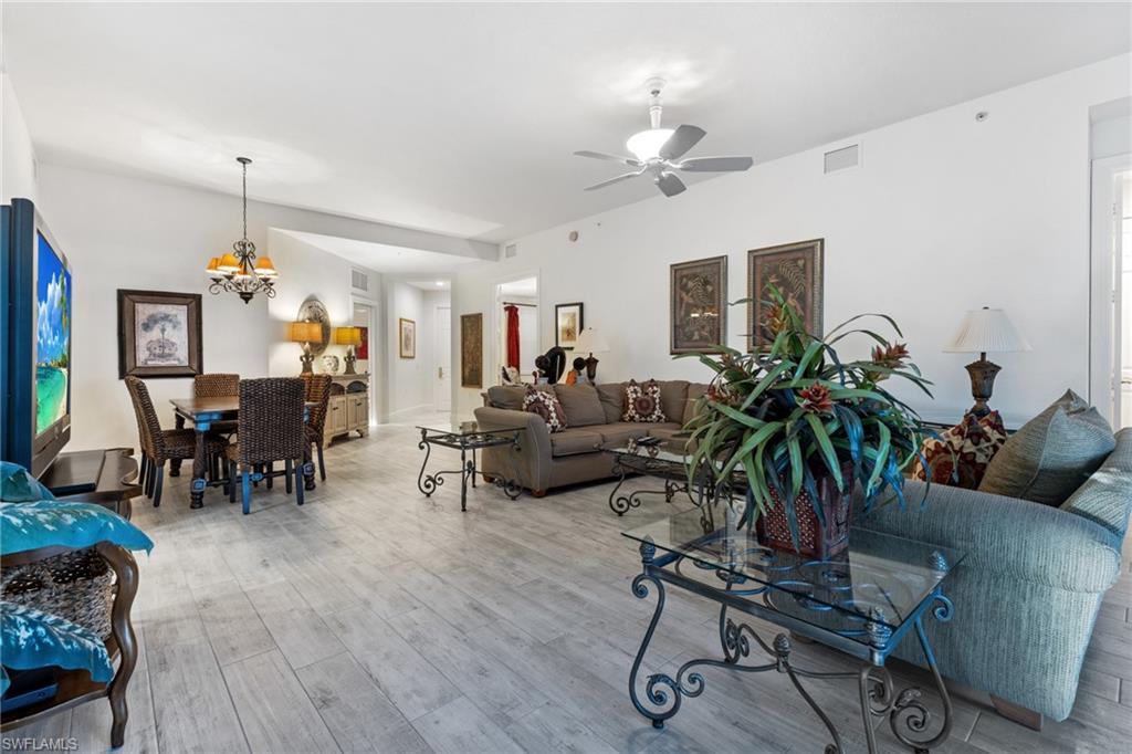 9079 Cascada Way, Unit 102 Naples, FL 34114 - Photo 5 of 49 a living room with furniture and a chandelier