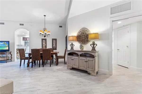 a view of dining room and kitchen with furniture chandelier and wooden floor