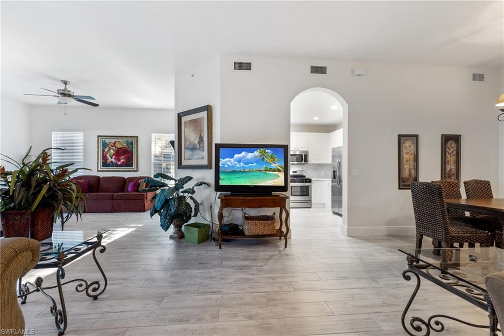 9079 Cascada Way, Unit 102 Naples, FL 34114 - Photo 10 of 49 a living room with furniture and a flat screen tv