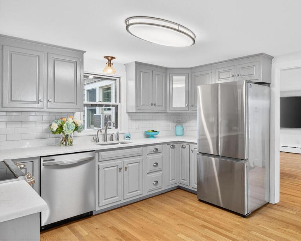 15 Geraldine Road Cotuit, MA 02635 - Photo 8 of 27 a kitchen with white cabinets and wooden floor