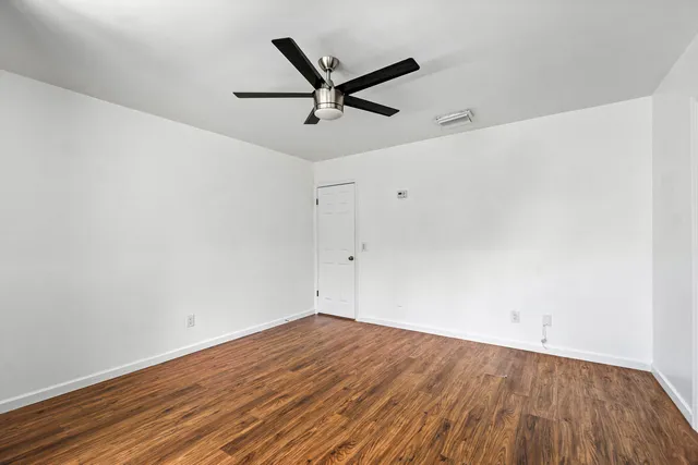 a view of a big room with wooden floor and a ceiling fan