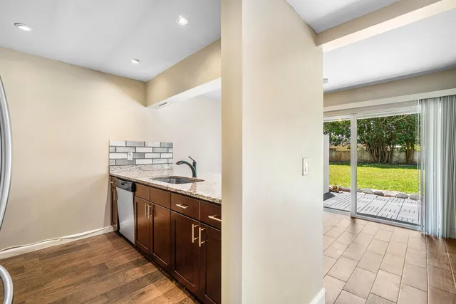 a view of a kitchen with a sink and wooden floor