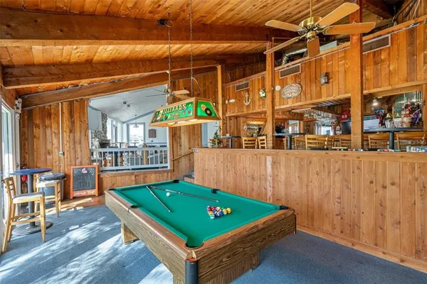 a room with pool table and windows