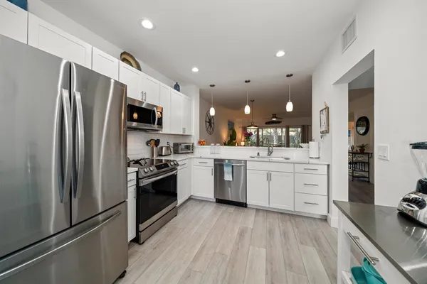 a kitchen with white cabinets and stainless steel appliances