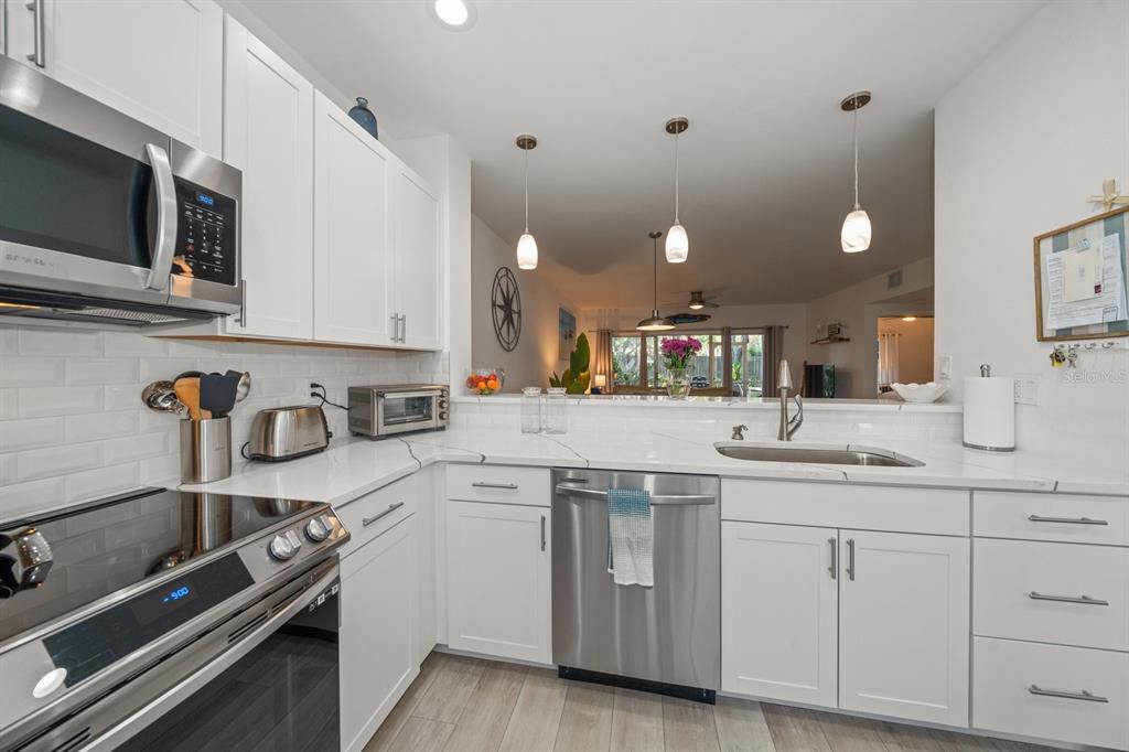 11300 Harbor Way, Unit 1734 Largo, FL 33774 - Photo 9 of 44 a kitchen with a sink stove and cabinets