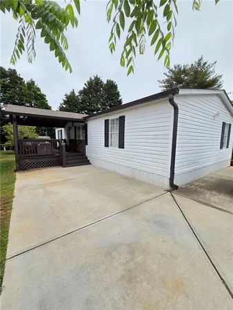 a view of house with backyard and trees in the background