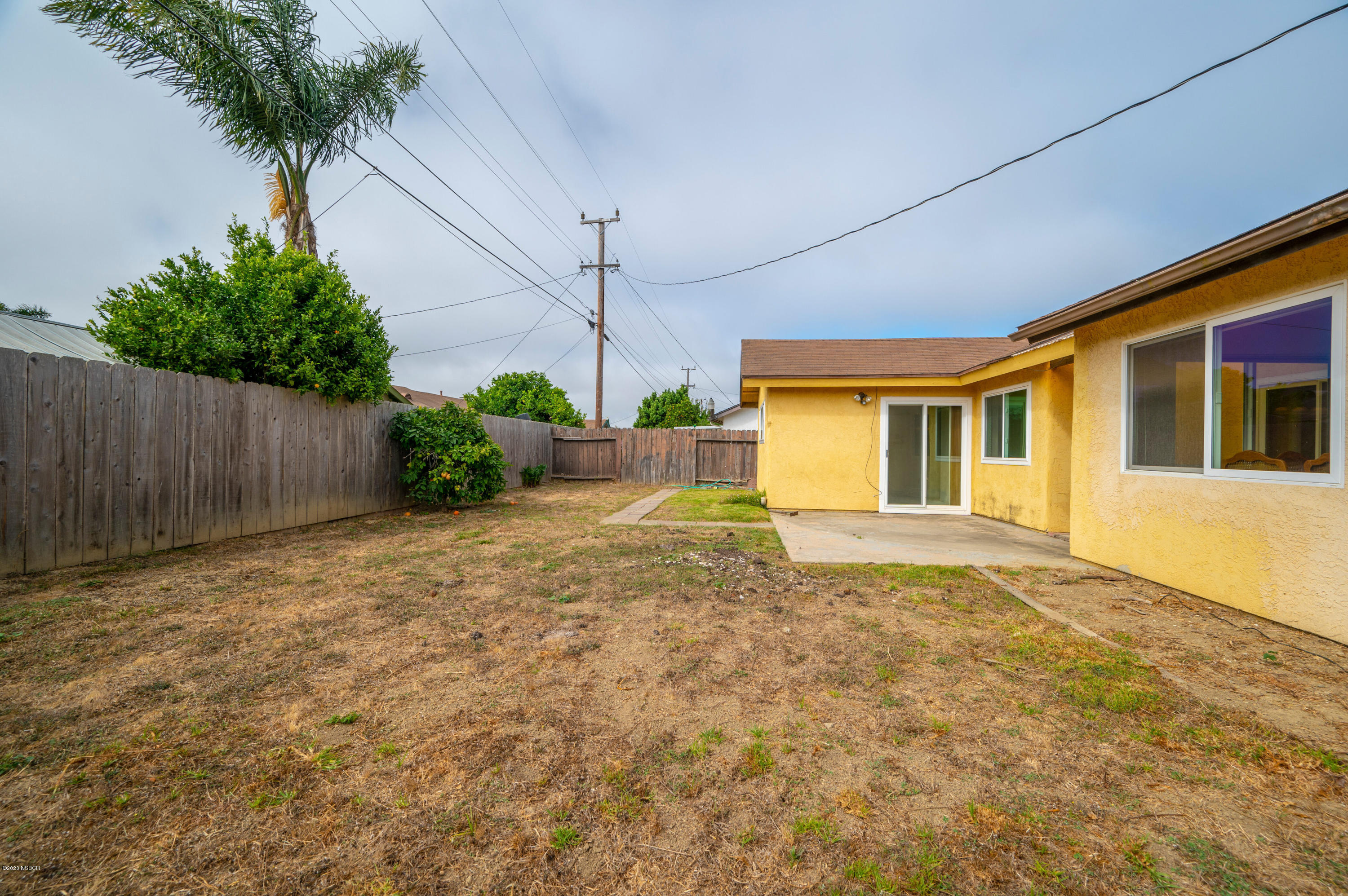 1008 West Anthony Way Lompoc, CA 93436 - Photo 23 of 26 a view of a house with a backyard and a garage
