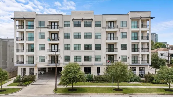 a front view of a residential apartment building with a yard