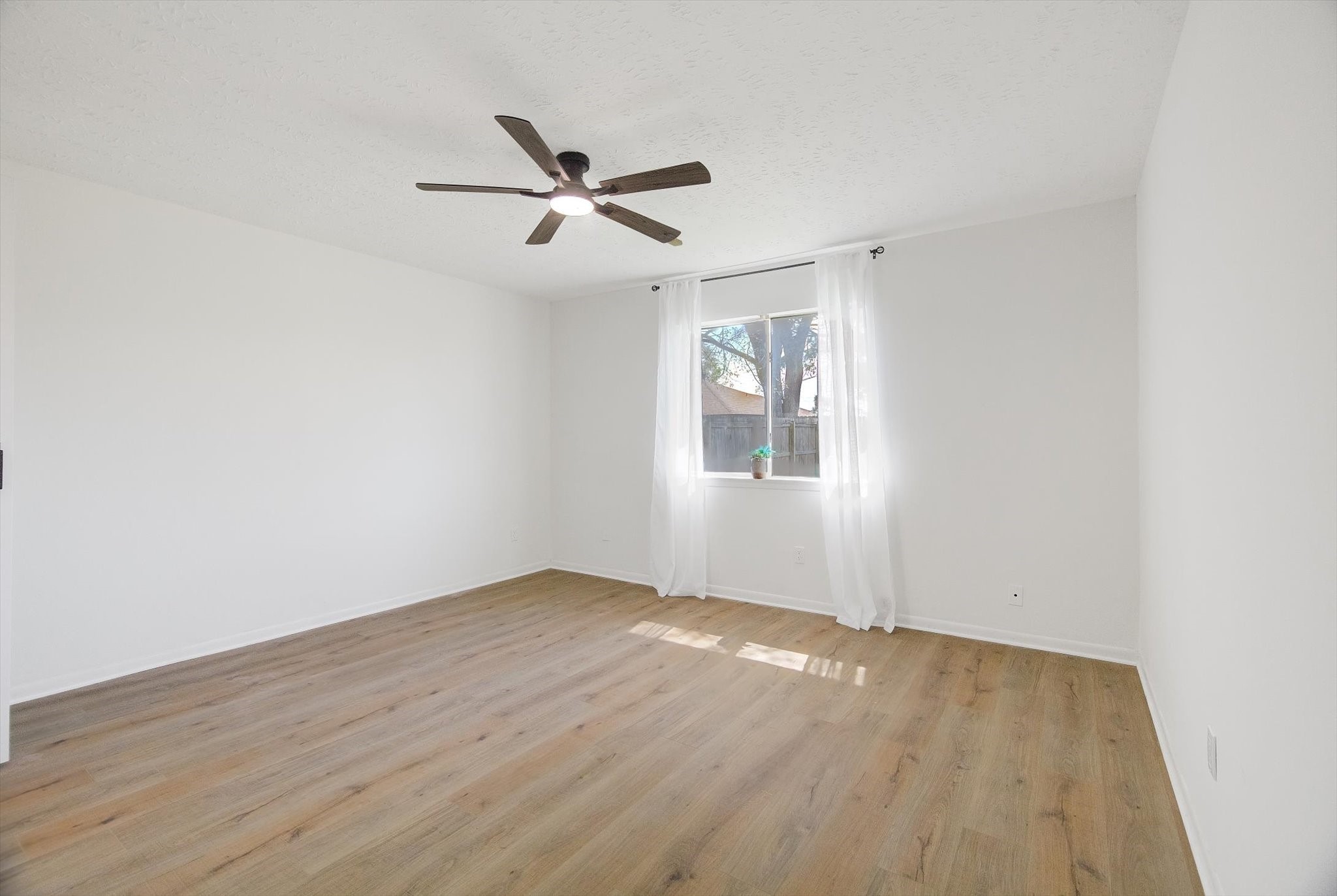 15110 Peachmeadow Lane Channelview, TX 77530 - Photo 17 of 34 an empty room with wooden floor fan and windows
