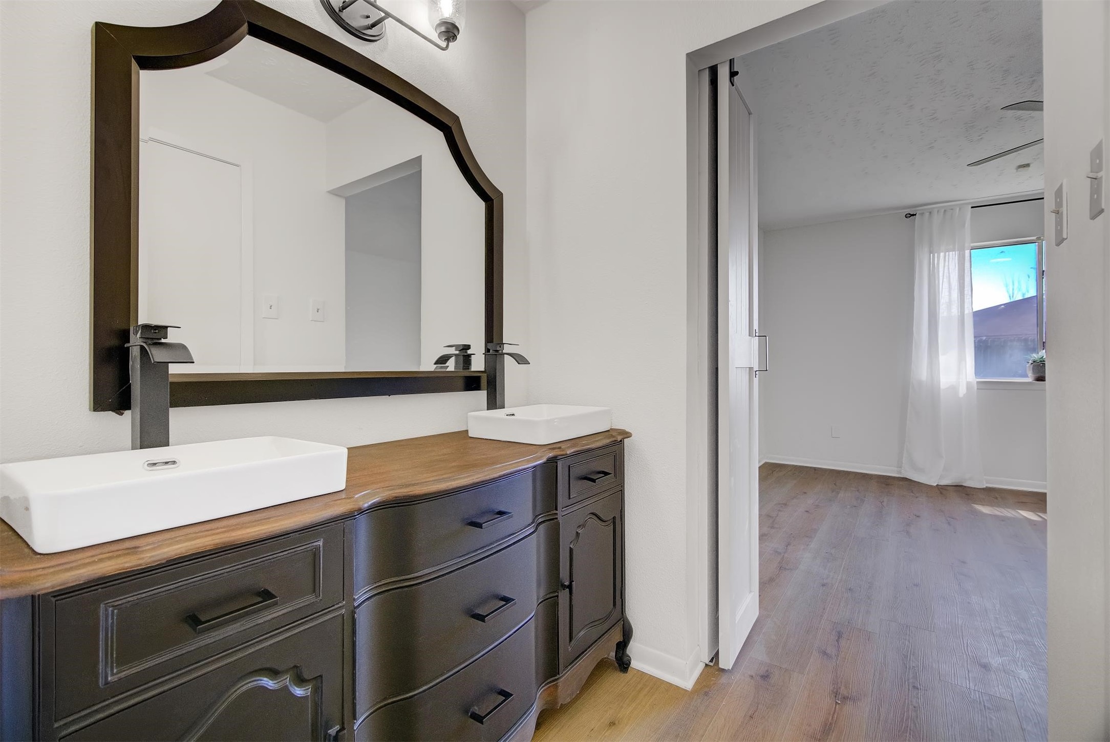 15110 Peachmeadow Lane Channelview, TX 77530 - Photo 21 of 34 a bathroom with a double vanity sink and mirror