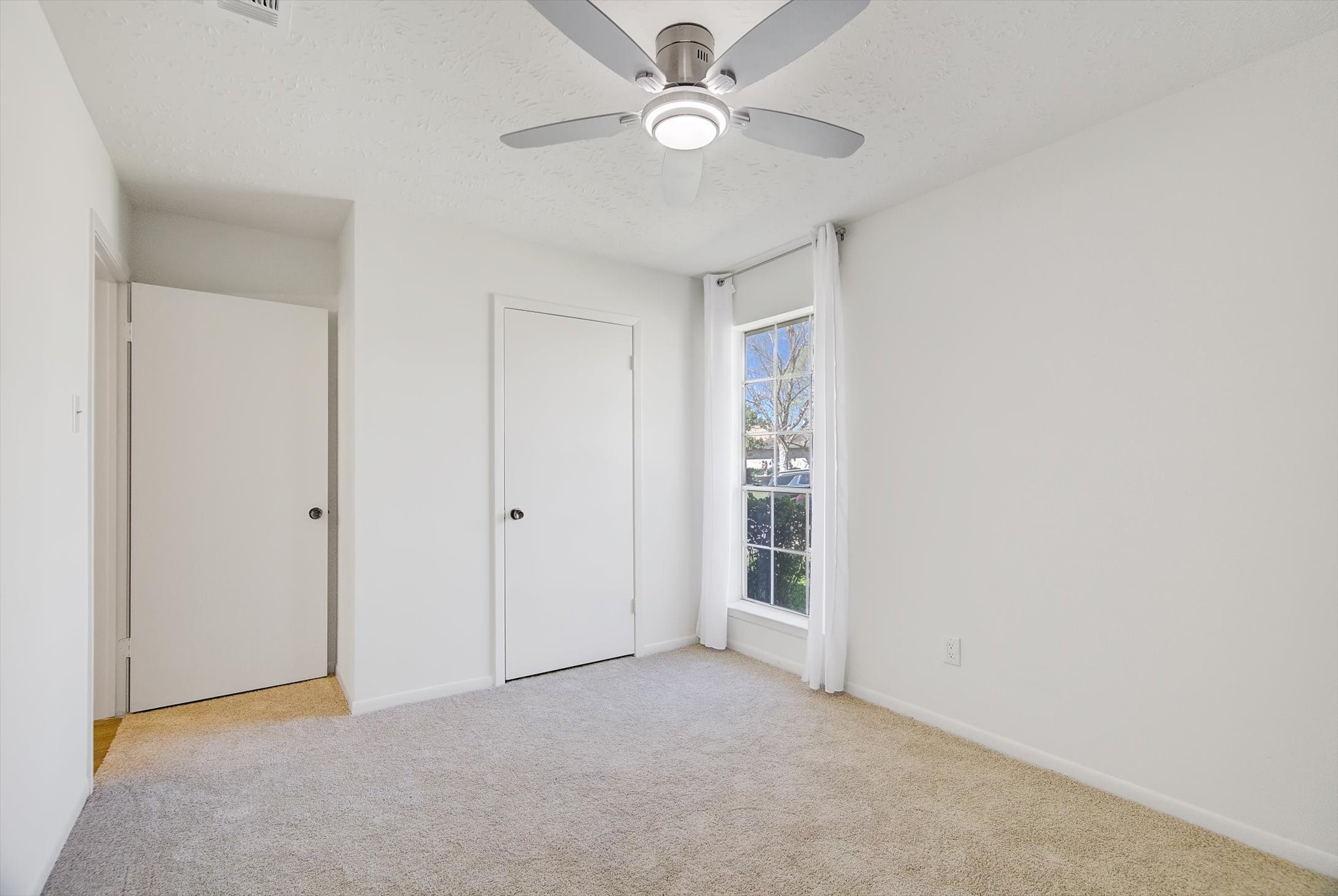 15110 Peachmeadow Lane Channelview, TX 77530 - Photo 27 of 34 an empty room with a ceiling fan and a window