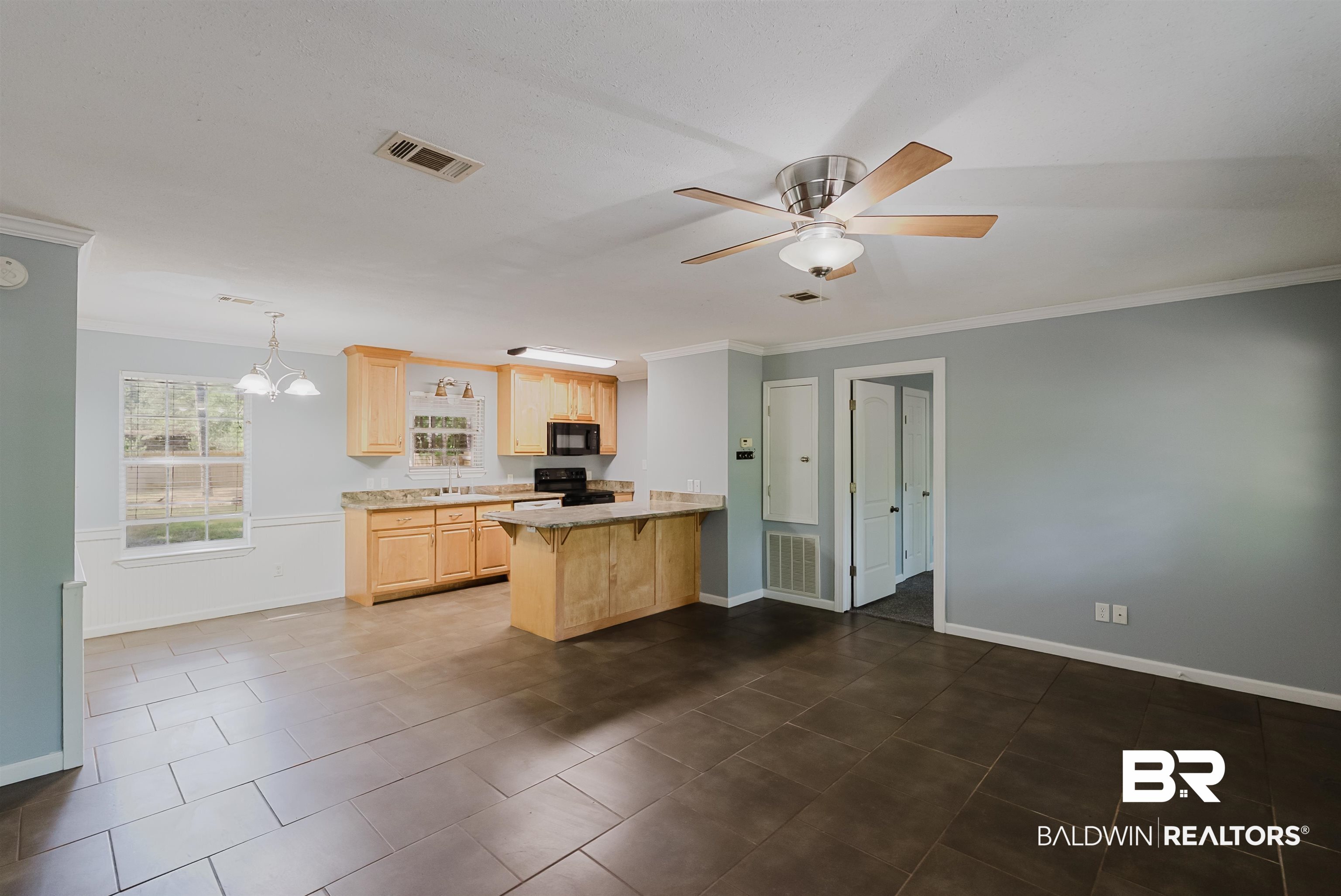 14185 Jackson Lane Foley, AL 36535 - Photo 4 of 16 Kitchen featuring light brown cabinets, a peninsula, crown molding, hanging light fixtures, and black appliances