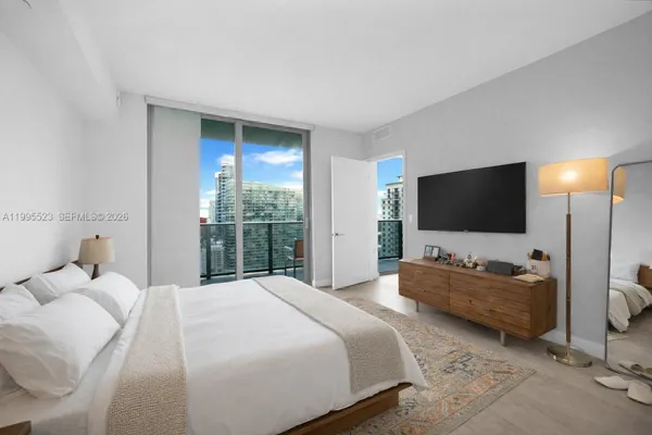 a bedroom with a bed and a flat screen tv