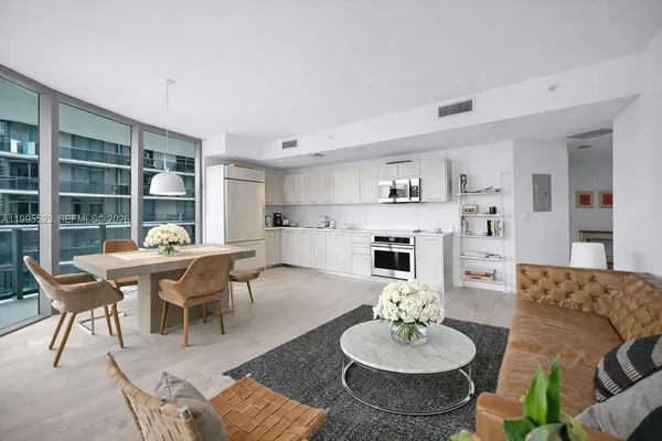 a living room with furniture and a dining table with kitchen view