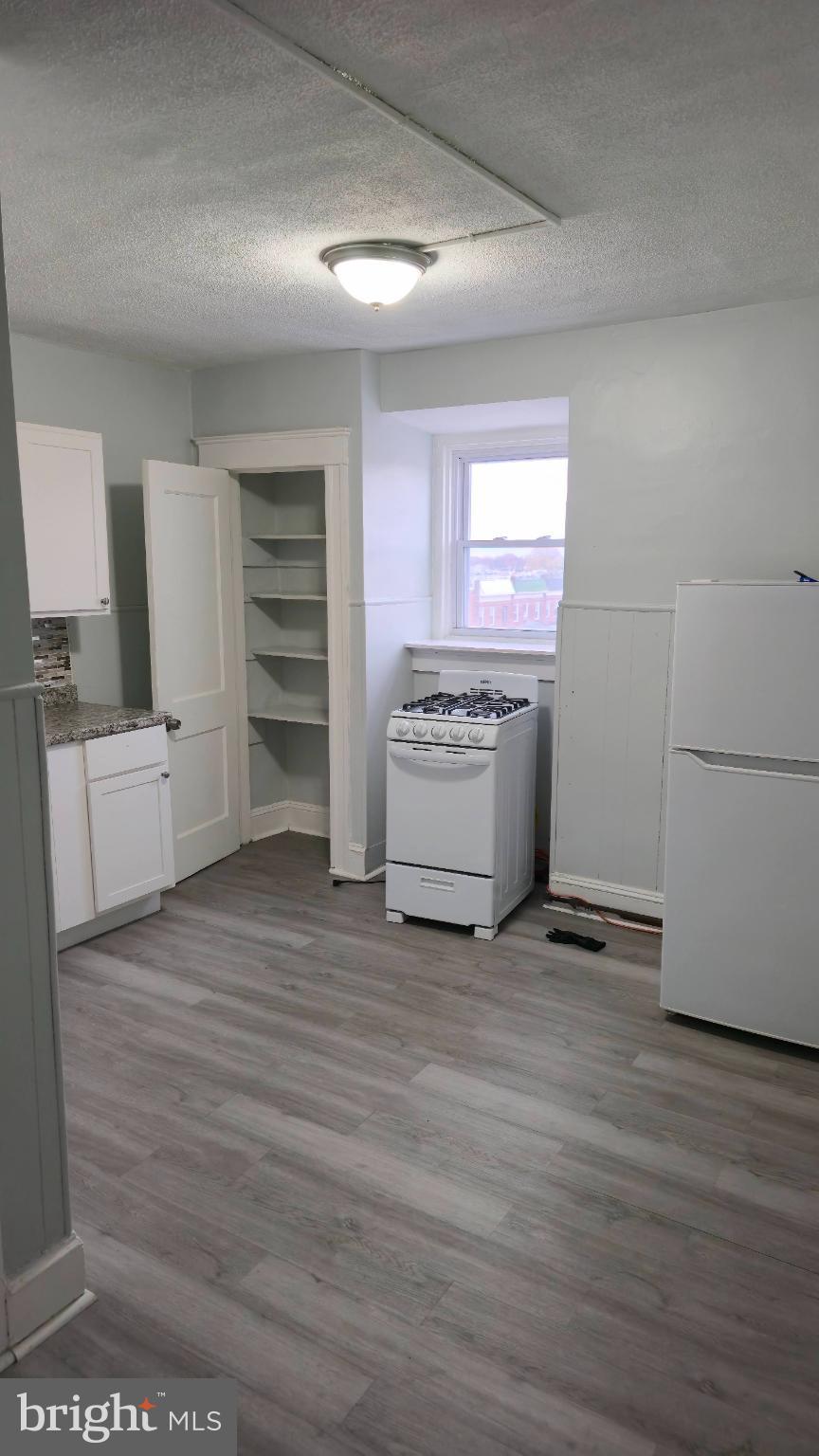 2413 Reisterstown Road Baltimore, MD 21217 - Photo 14 of 22 a view of a kitchen with a sink oven cabinets and a refrigerator