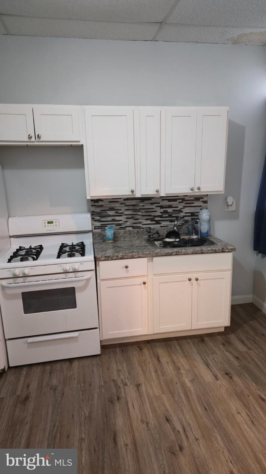 2413 Reisterstown Road Baltimore, MD 21217 - Photo 3 of 22 a kitchen with granite countertop a stove and a wooden floors