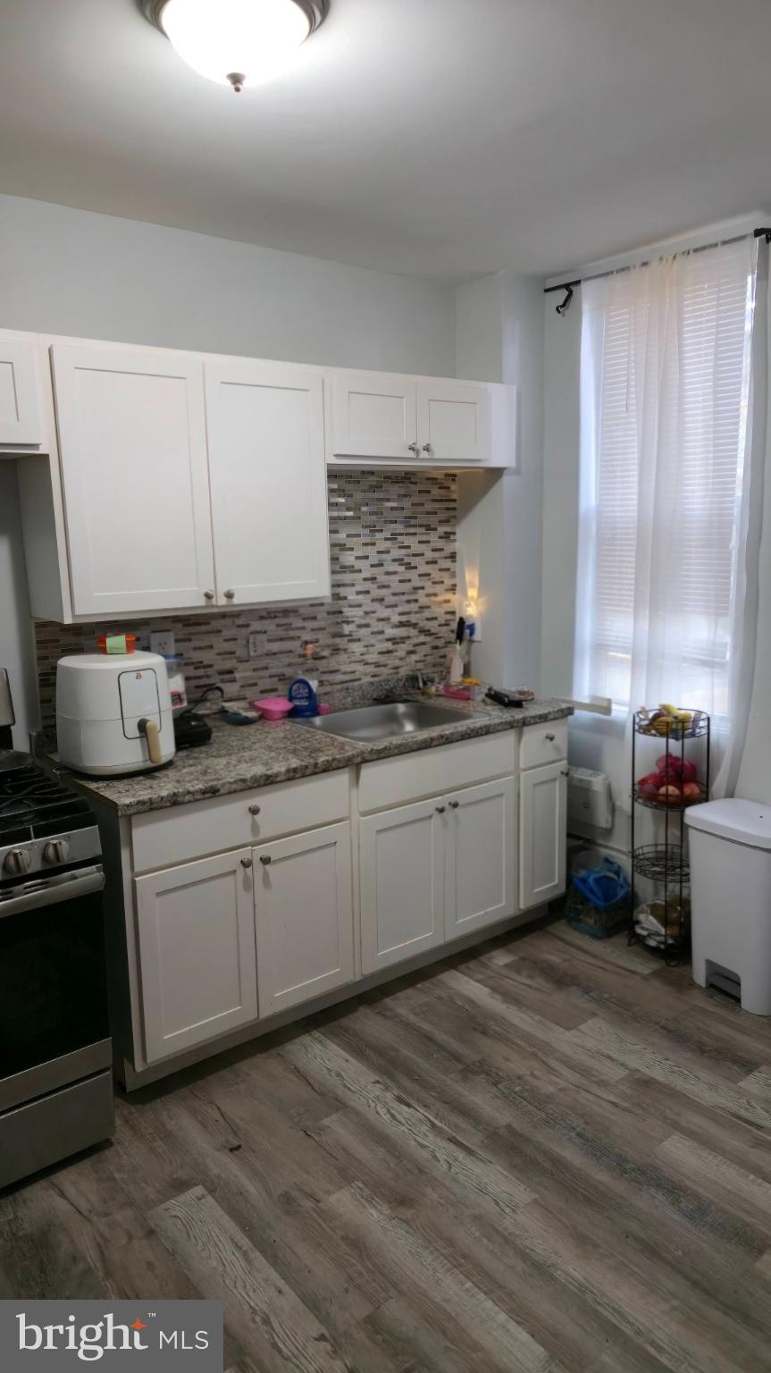 2413 Reisterstown Road Baltimore, MD 21217 - Photo 8 of 22 a kitchen with granite countertop a sink stainless steel appliances and cabinets