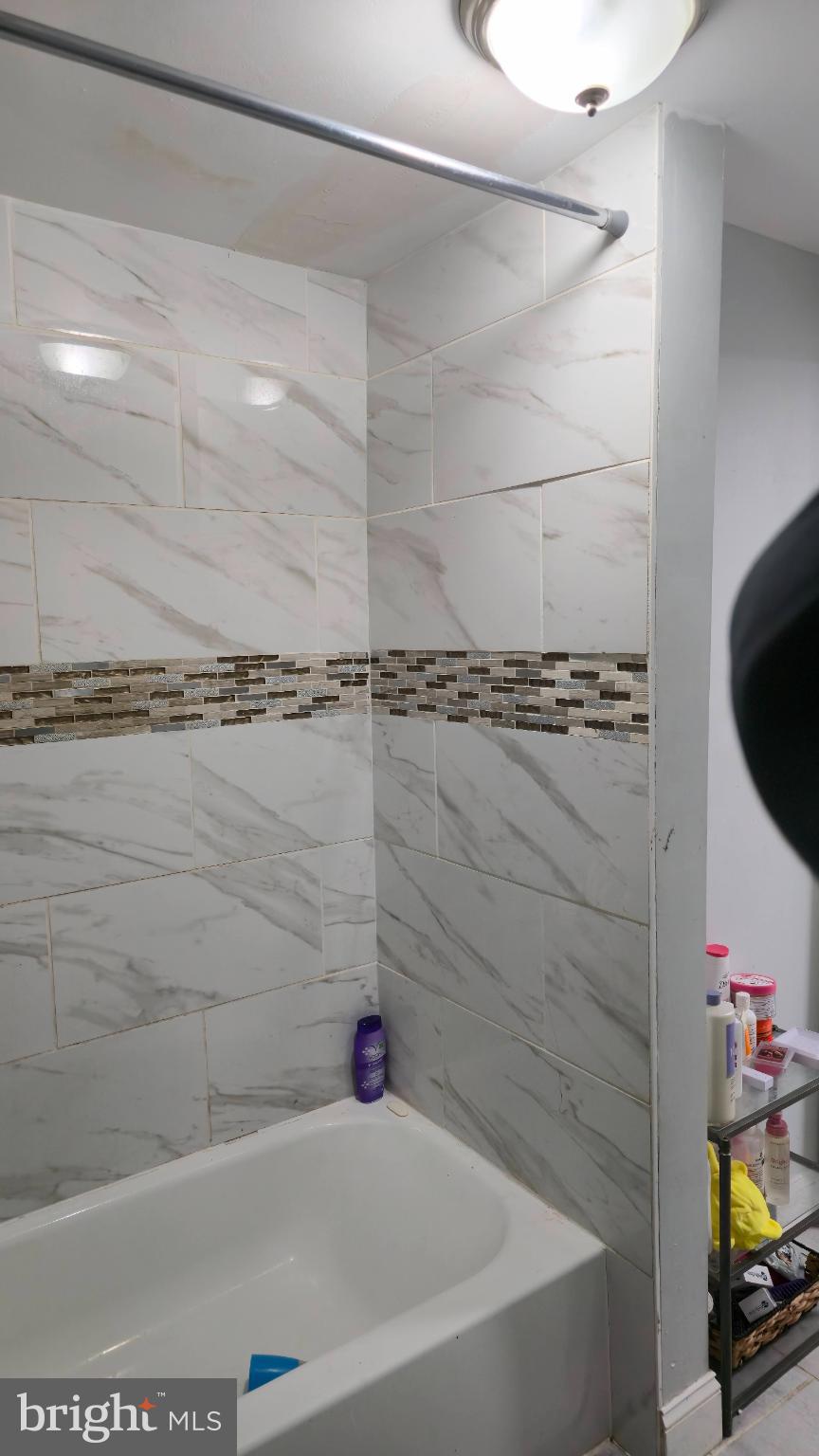 2413 Reisterstown Road Baltimore, MD 21217 - Photo 9 of 22 a bathroom with a bathtub and a shower