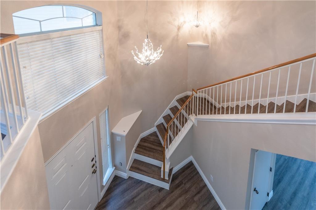 12017 Springs Head Loop Austin, TX 78717 - Photo 4 of 25 Grand two-story entrance featuring elegant chandeliers and a gracefully sweeping staircase.