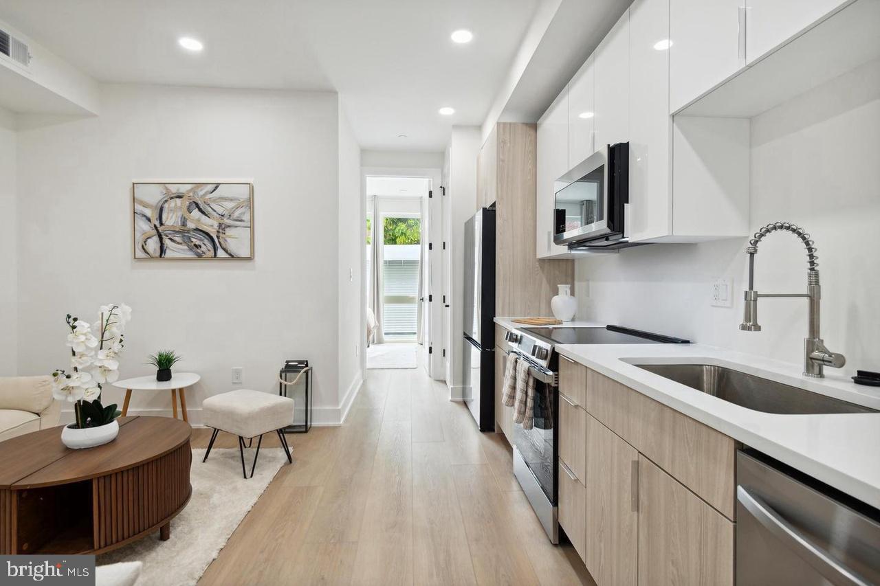 705 Quincy Street Northeast, Unit 4 Washington, DC 20017 - Photo 2 of 7 a kitchen with stainless steel appliances granite countertop a sink and a stove top oven