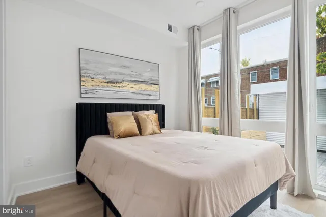 a large bed sitting in a bedroom next to a window